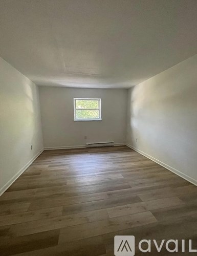 A room with wooden flooring and a window.