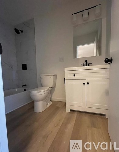 A white bathroom with a toilet, sink, and cabinet.