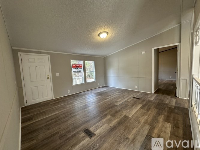 A room with wooden flooring and a white door.