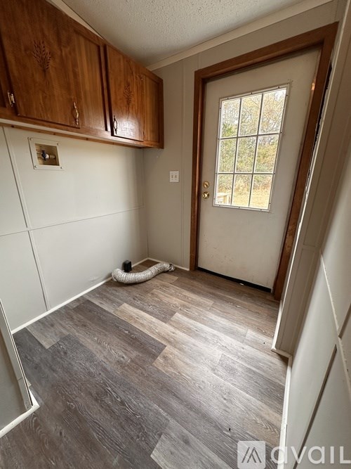 A room with wooden cabinets and a door leading to a window.