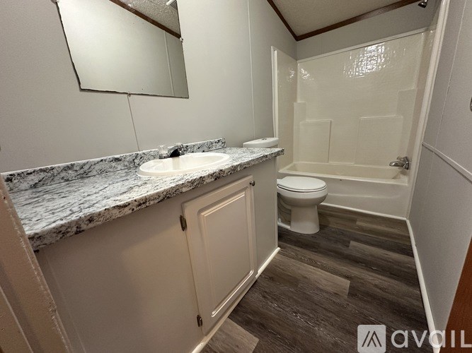 A bathroom with a marble countertop and a white toilet.