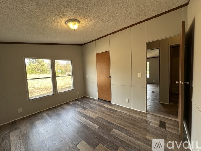 A room with wooden flooring and a ceiling light.
