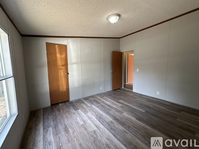 A room with wooden floors and two doors.