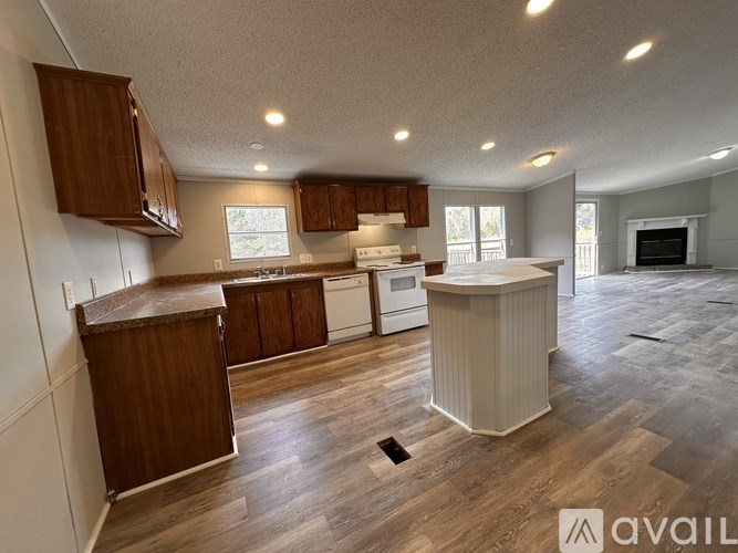 A kitchen with wooden cabinets and a white countertop is available for rent.