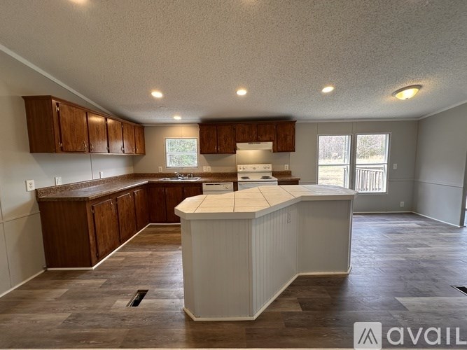 A kitchen with wooden cabinets and a white island.