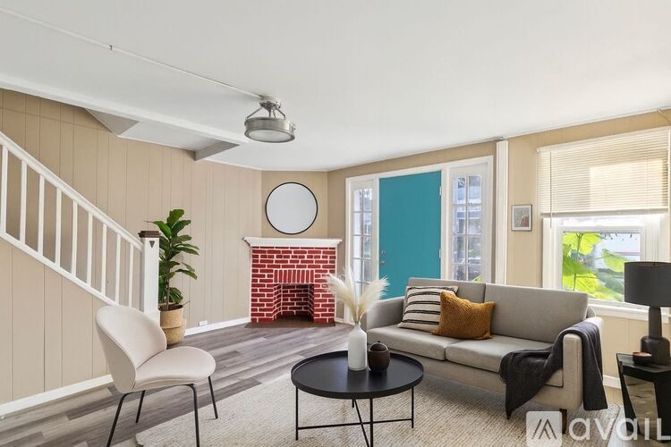 A living room with a white couch, a black coffee table, and a white chair.