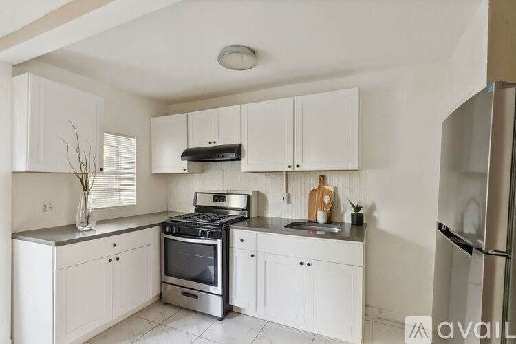 A kitchen with white cabinets and a black stove top oven.