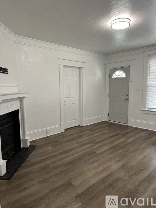 A room with a fireplace and wood flooring.