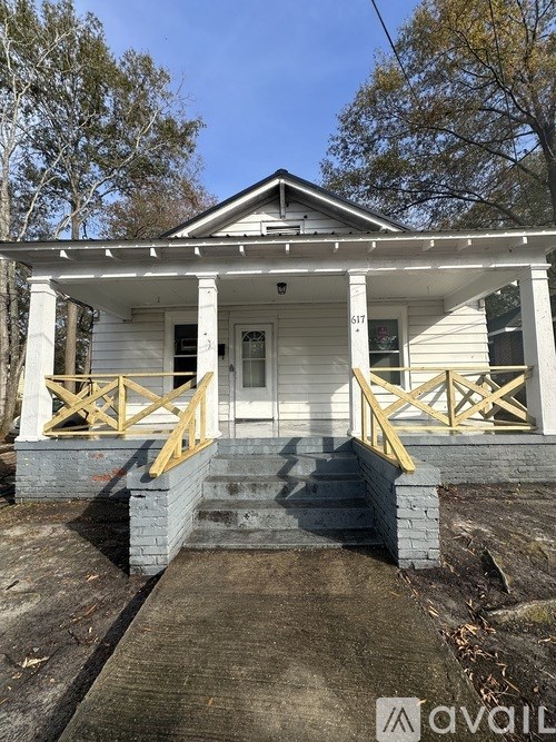 A white house with a porch and stairs leading up to the front door.