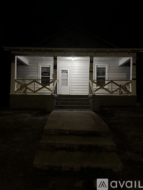A house with a white door and steps leading up to it.