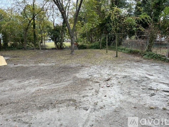 A dirt field with trees in the background.