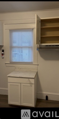 A white cabinet with a window above it.
