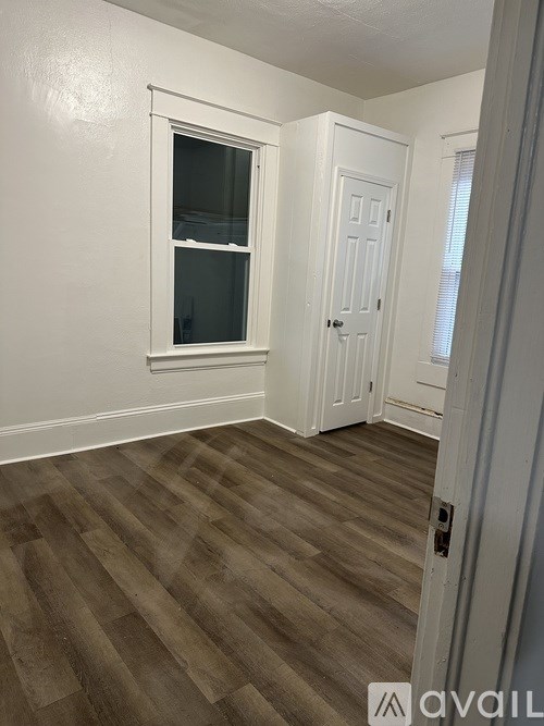 A room with a wooden floor and white walls.