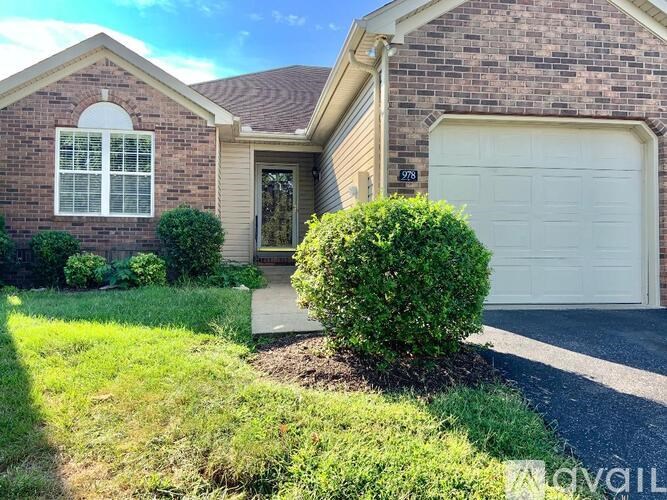 A house with a white garage door and a window with white blinds.