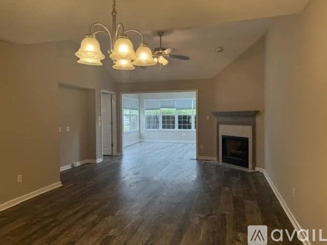 A living room with a fireplace and a ceiling fan.