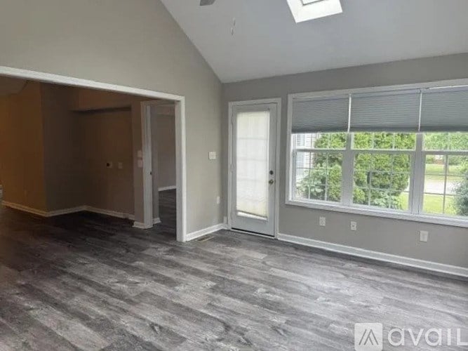 A room with a grey carpet and a window with blinds.