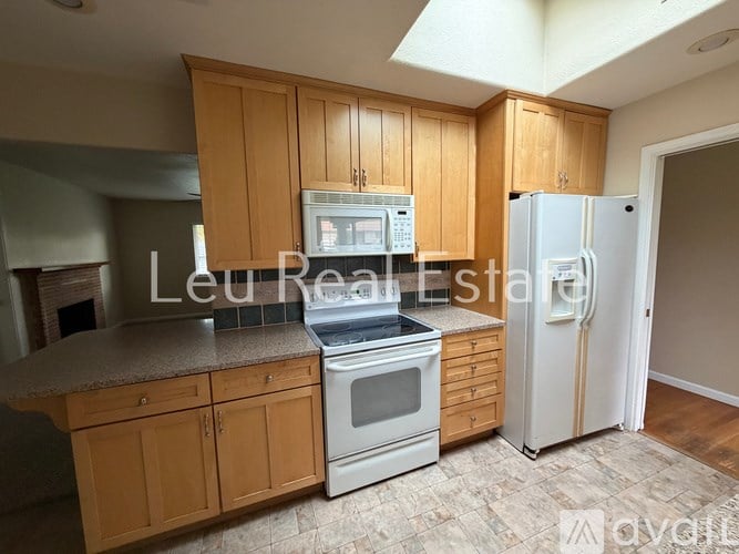 A kitchen with wooden cabinets and a white refrigerator.