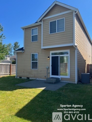 A house with a Spartan Agency logo and contact information on the front yard.