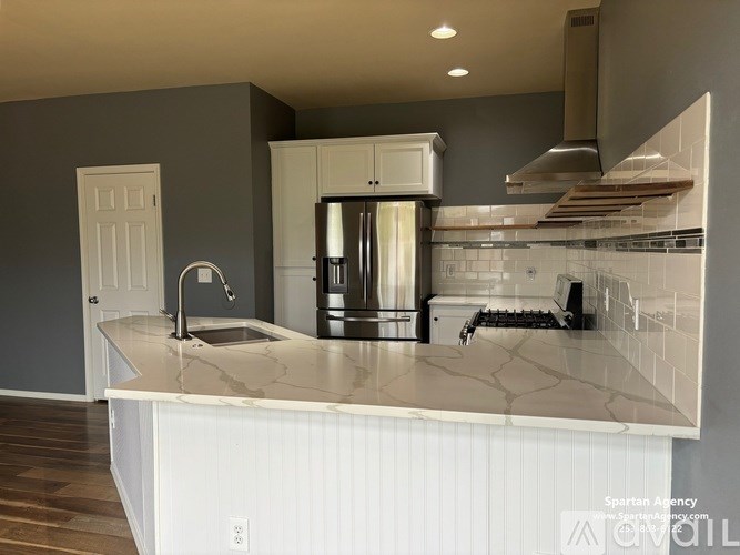 A kitchen with a marble countertop and a sink.