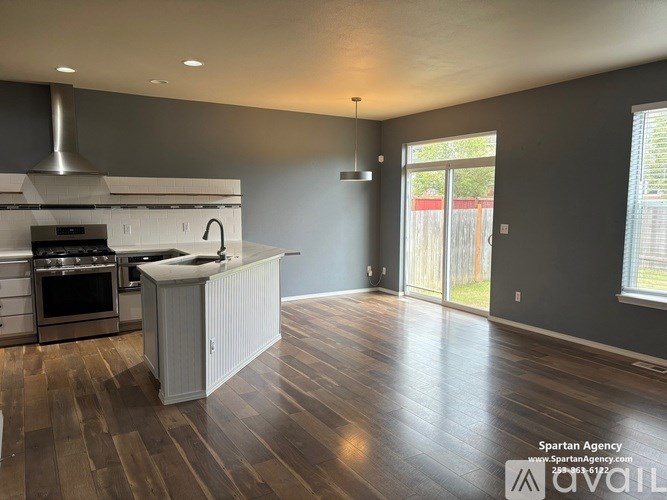 A kitchen with a white island and stainless steel appliances.