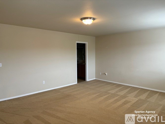 A room with a wooden floor and a door on the right side.