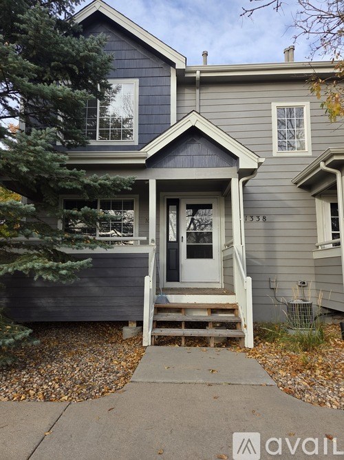 A house with a grey front and a white door.