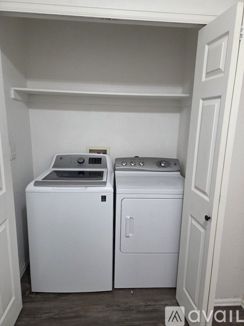 A white washing machine and dryer in a small laundry room.