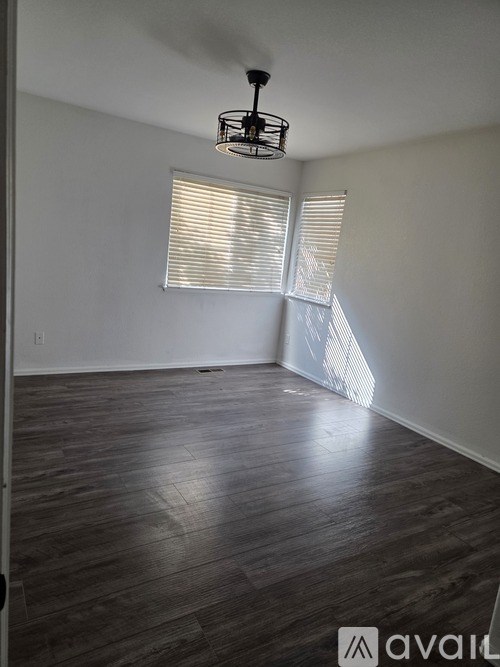 A room with wooden flooring and a light fixture.