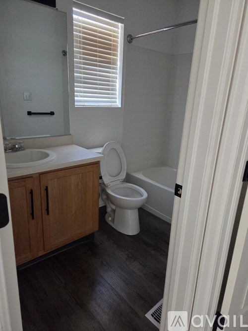 A bathroom with a toilet, sink, and shower.
