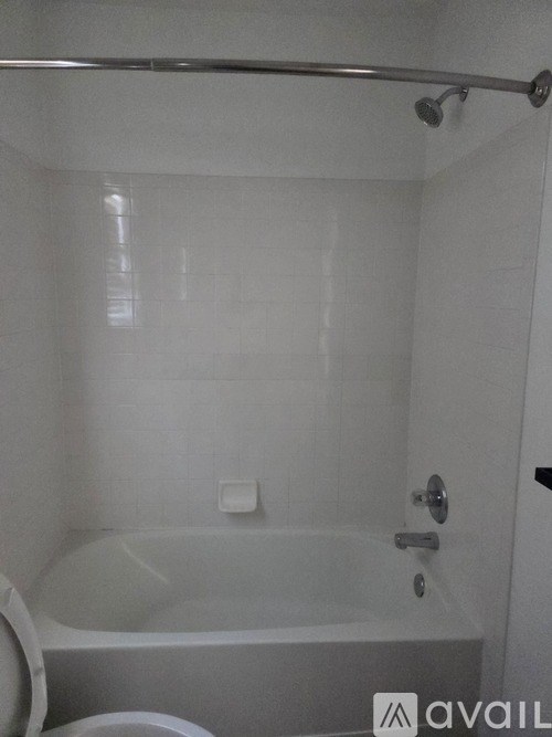 A white bathroom with a tub and toilet.