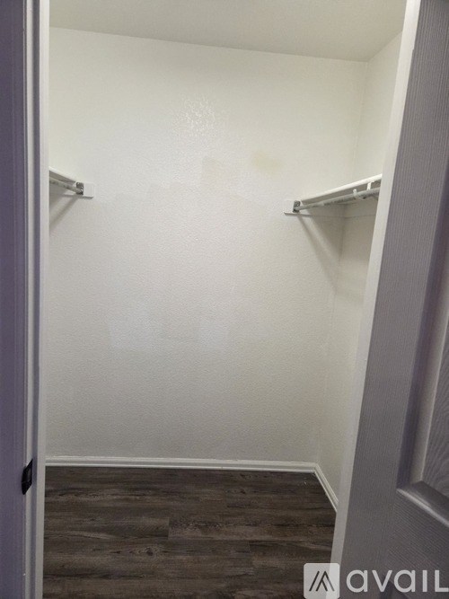 A room with a white wall and a grey door.
