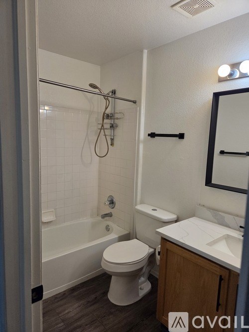 A bathroom with a toilet, sink, and bathtub.