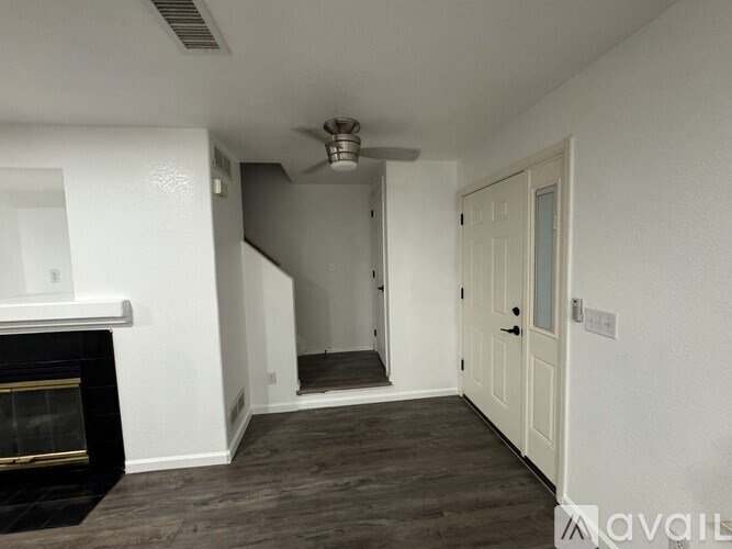A living room with a fireplace and a staircase.