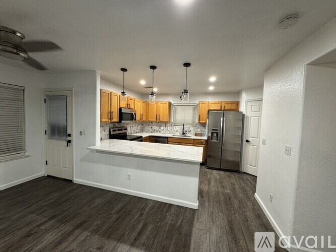 A kitchen with wooden cabinets and a marble countertop.
