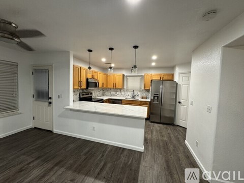 A kitchen with wooden cabinets and a marble countertop.