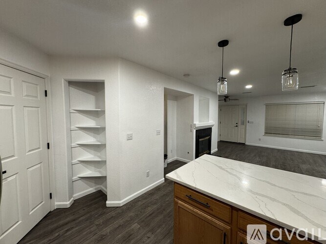 A kitchen with a white countertop and wooden cabinets.