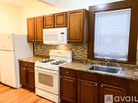 A kitchen with brown cabinets and a white stove.