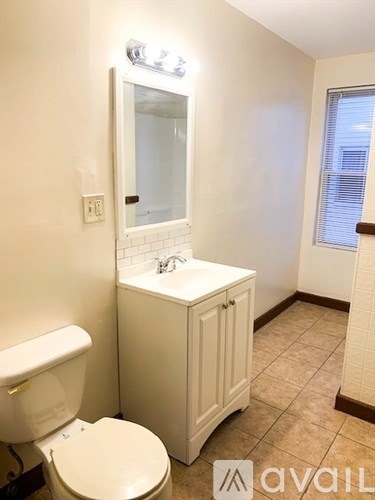 A white toilet sits next to a sink in a small bathroom.