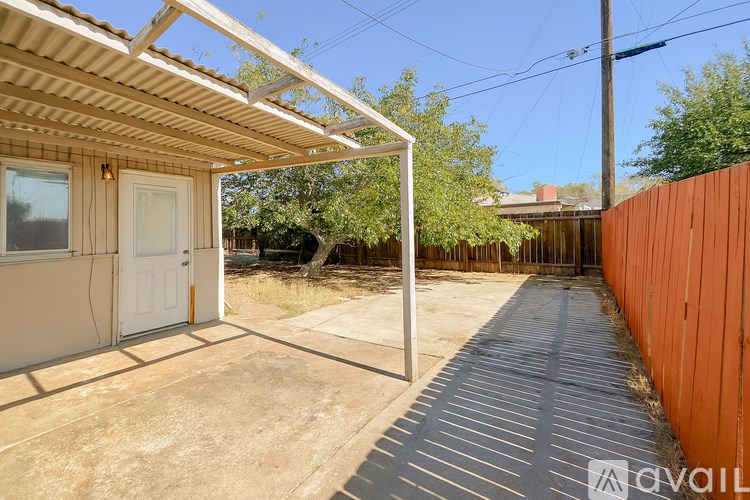 A patio area with a white door and a wooden pergola.
