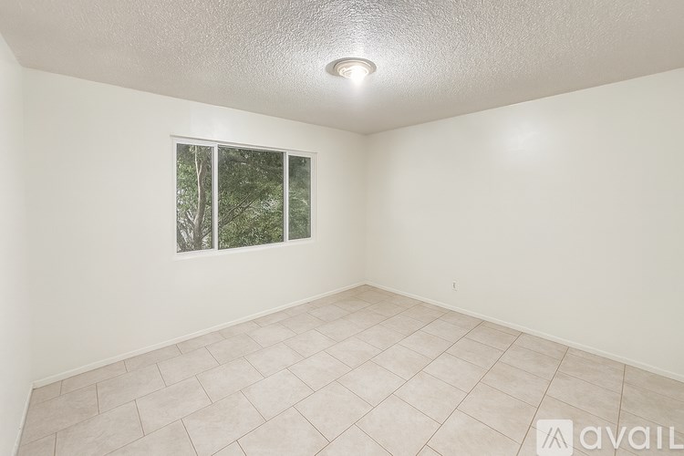 A room with a window and tiled floor.