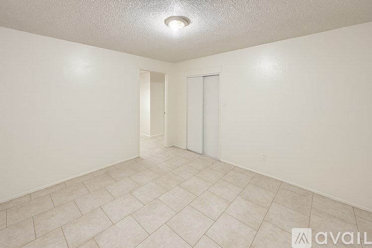 A spacious room with tile flooring and two doors.