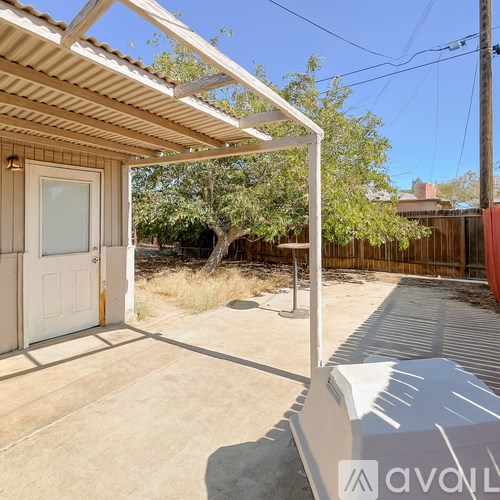 A patio area with a white door and a roof.
