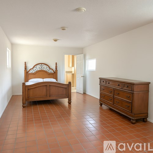 A bedroom with a bed and a dresser.