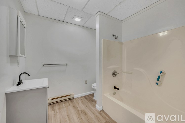 A bathroom with a white tub and a white sink.