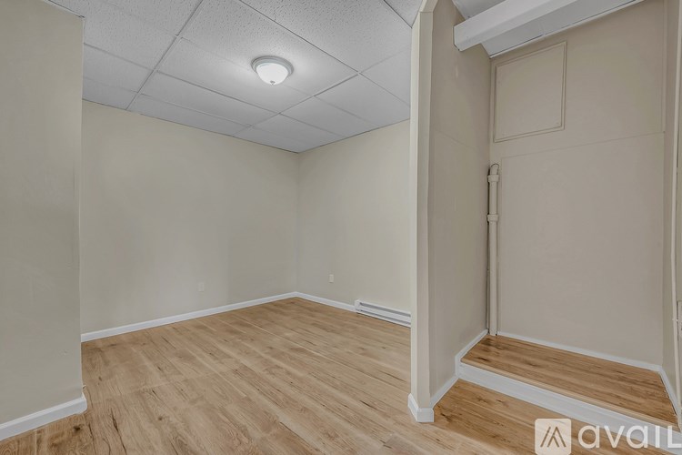 A room with wooden flooring and a white ceiling with a light fixture.