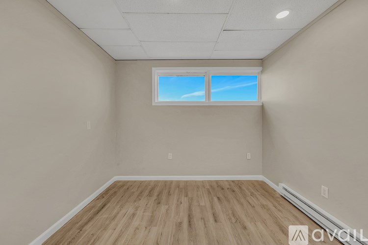 A room with wooden flooring and a window.