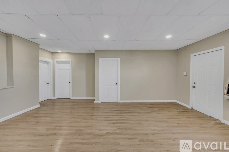 A room with wooden flooring and white doors.