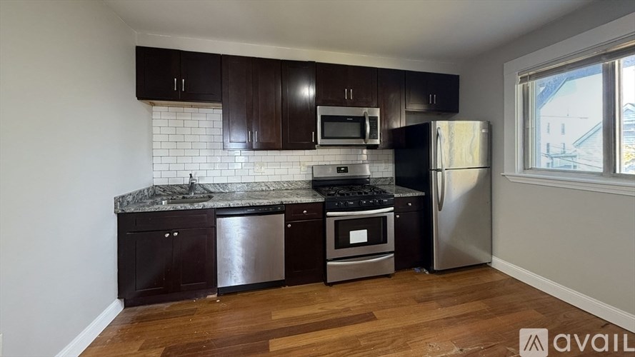 A kitchen with dark wood cabinets and stainless steel appliances.