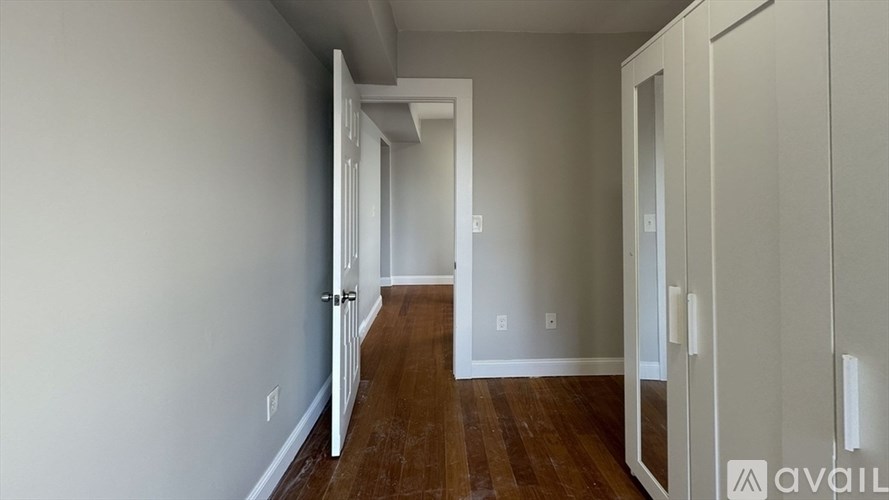 A hallway with a door on the right and a wall on the left.