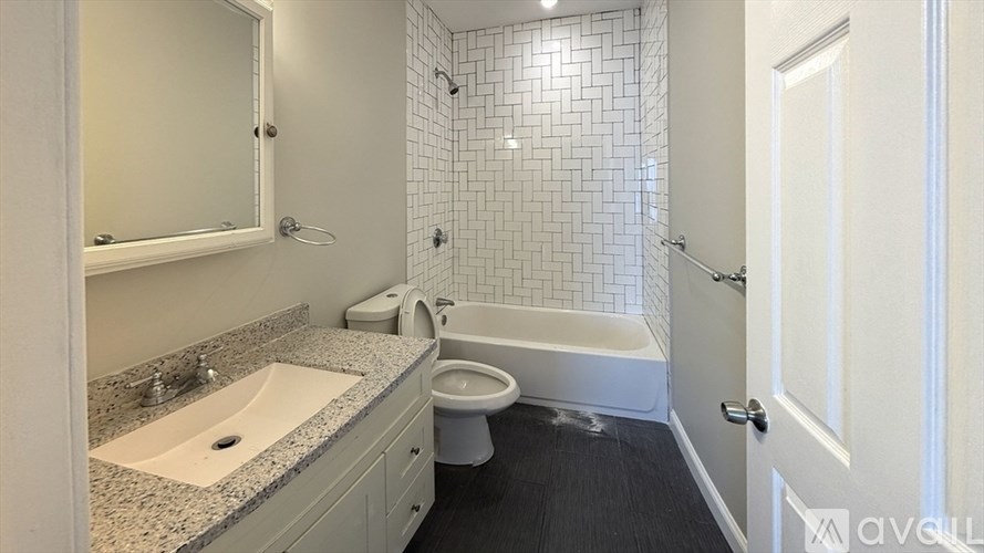 A bathroom with a sink, toilet, and bathtub.